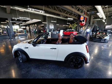 A sales associate talks with a prospective buyer of a Cooper SE electric vehicle on the showroom floor of a Mini dealership July 7, 2022, in Highlands Ranch, Colorado.