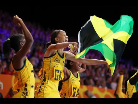 Nicole Dixon-Rochester (left) and Shamera Sterling (centre) of Team Jamaica celebrate victory over New Zealand in the semi-final of the Commonwealth Games at the NEC Arena in Birmingham, England on Saturday.