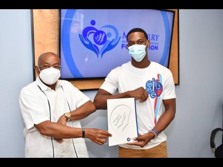 Vice-President of Mayberry Investments Limited Konrad Berry (left) shares a proud moment with St George’s College track team co-captain, De’Andre Bristol. On behalf of the Mayberry Foundation, Bristol received a token from Berry for his high-grade perf