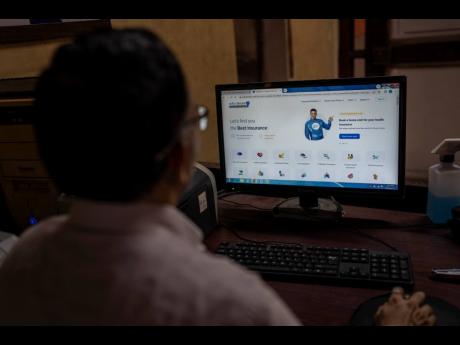 A man looks at the website of Policybazaar at a local insurance company office in Mumbai, India, on Wednesday, August 10.