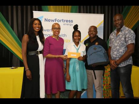 Education Minister Fayval Williams (second left) presents  Abbigayle Thompson, student of the Denbigh High School, with her scholarship while Pearnel Charles Jr (second right), MP for Clarendon South East, presents her with a backpack. Also present are Ver