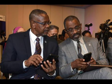 Paul Chin (left), manager of investor relationship at the Development Bank of Jamaica (DBJ), and DBJ Managing Director Anthony Shaw in discussion at the launch of the DBJ’s loans for the entertainment and transport sectors at the AC Marriott in Kingston 