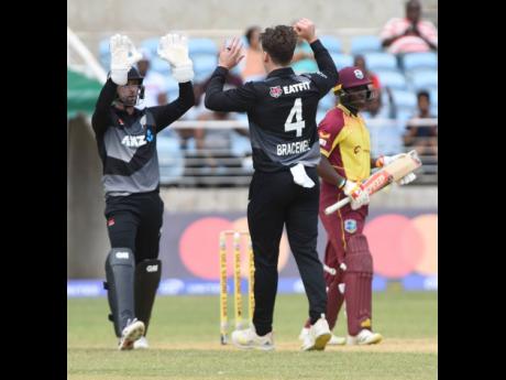Devon Conway (left) of New Zealand congratulates spinner Michael Bracewell (centre) after Bracewell trapped West Indies’ Devon Thomas (right) leg before wicket during yesterday’s second T20 International match at Sabina Park.