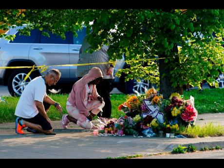 People pay their respects outside the scene of a shooting at a supermarket in Buffalo, N.Y., Sunday, May 15, 2022. 