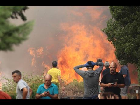 Neighbours stand near a forest fire in Añon de Moncayo, Spain. 