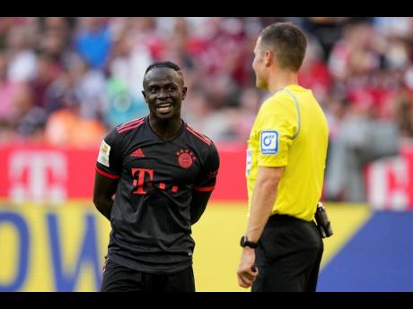 Bayern’s Sadio Mane talks with referee Harm Osmers while waiting for a VAR decision during the German Bundesliga match between FC Bayern Munich and VfL Wolfsburg in Munich, Germany, yesterday.