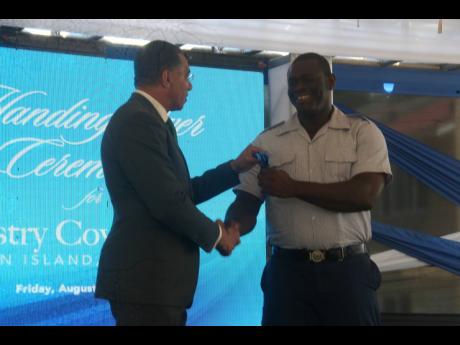 Prime Minister Andrew Holness (left) hands over a set of keys to Shawn Anderson for his newly acquired home in the Industry Cove Manor housing development, located in western Hanover, on Saturday, August 13.
