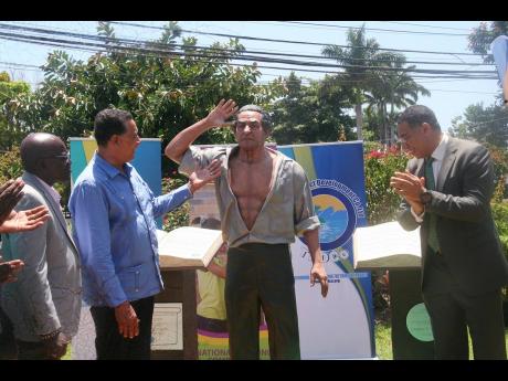 Prime Minister Andrew Holness (right) participates in the unveiling of a statue of National Hero Alexander Bustamante on the grounds of the Hanover Parish Library in Lucea on Friday. Also in the photo are Lucea Mayor Sheridan Samuels (left) and Minister of