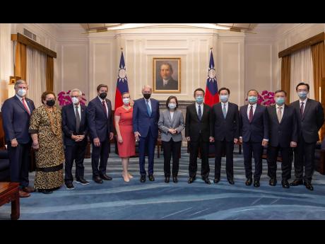 In this photo released by the Taiwan Presidential Office, Taiwan’s President Tsai Ing-wen poses for photos with US Congress members and other Taiwan officials during a meeting at the Presidential Office in Taipei, Taiwan, on Monday, August 15.