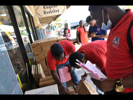 Workers checking book stocks outside Kingston Bookshop in The Springs Plaza as back-to-school shopping gets into full gear Monday.