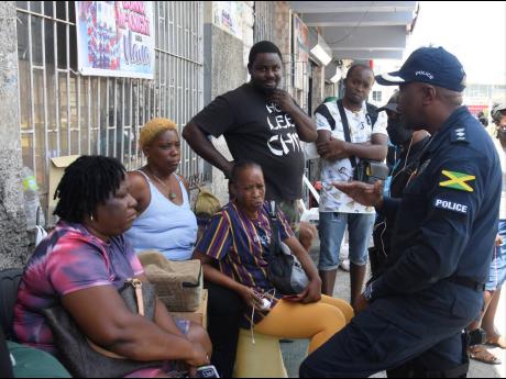 Senior Superintendent of Police Vernon Ellis engages in discussion with street vendors at Sam Sharpe Square in Montego Bay as a 14-day crackdown on public disorder got under way in the western city on Monday.