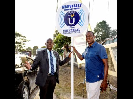 From left: Daniel Dawes, CEO of Universal Service Fund, and finance minister Dr Nigel Clarke, member of parliament for St Andrew North West, point to the Wi-Fi sign at the launch at Borien Avenue in Maverley, St Andrew, on August 15.