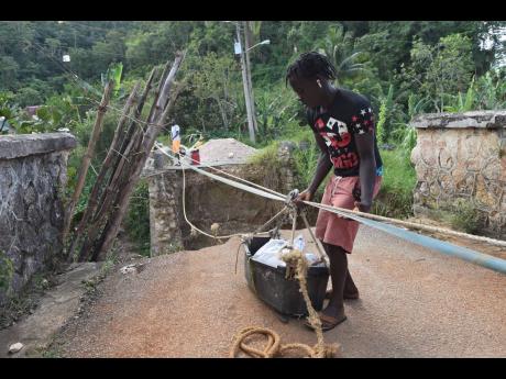 left: Residents of Troy use a makeshift pulley to transport goods over the Hector River after the community bridge collapsed. 