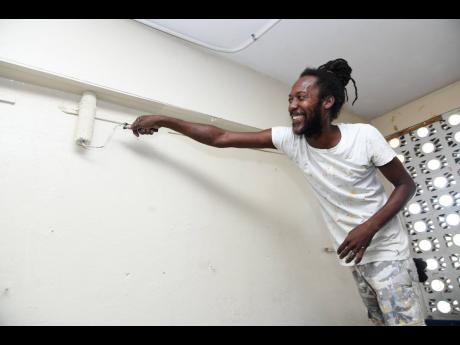 Hodari Newman painting a classroom at the Allman Town Primary School on Monday as the Kington-based institution prepares for the reopening of school.