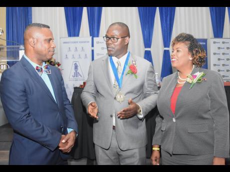 Winston Smith (centre), outgoing president of the Jamaica Teachers’ Association (JTA) in discussion with Colin Greene (left), past president, Caribbean Union of Teachers, and La Sonja Harrison, president-elect, JTA, at the opening ceremony of the 58th An