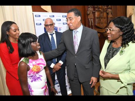 Sidonie Eldermire (second left), one of the beneficiaries, chats with (from left) Ashley Horne, managing director of Arc Properties Limited; Keith Duncan, president of the Private Sector Organisation of Jamaica; Prime Minister Andrew Holness, and Audrey Se