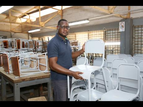 Simmonds shows a stack of chairs that have been completed by his team for dispatch as part of the Ministry of Education’s school furniture project. 