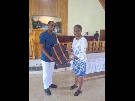 Principal Melbourne Thompson of Bermaddy Primary accepts a bag from Pauline Beecher of the Beecher Foundation at a recent function.