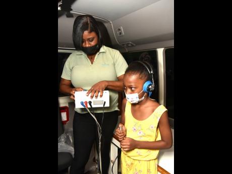 Nurse Crystal Gayle checks Abigail Chin’s hearing during the Sagicor Wellness tour which kicked off on Saturday, August 20, at Devon House, offering free medicals and health checks to patrons in attendance. The second leg of the tour will be held at Harm