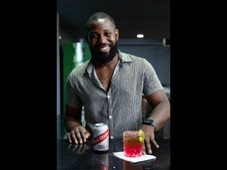 Kingsley Morgan with the King’s Sunrise – a refreshing infusion of strawberry, citrus, gin and Red Stripe flavours.