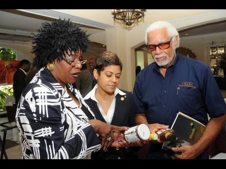 Winston Stona (right) co-founder of Busha Browne’s inspects products with Deika Morrison (centre) and Dr Beverly Morgan.