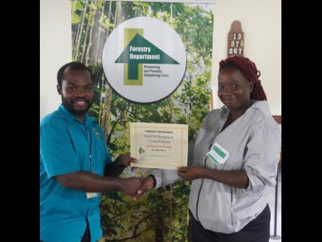 Whitney Stewart accepts her certificate of participation for the recent forest fire management training session.