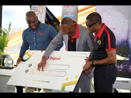 Keith Wellington (centre), President of the Inter-Secondary Schools’ Sports Association (ISSA), point to the Digicel sponsorship amount of $84 million while he stands with Elon Parkinson (left), Public Relations and Communications Manager, Digicel, and L