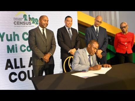 Dr Nigel Clarke, minister of finance and the public service, signs the Census Order and the Census Regulations 2022, while looking on are (from left) Julian Robinson, representing the Opposition leader; Prime Minister Andrew Holness; Professor David Tennan