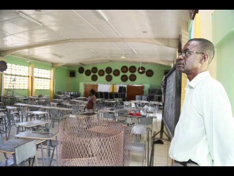 O’Neil Lewin, acting principal of Vere Technical High School in Clarendon, inspects the auditorium, which doubles as a classroom and meeting area because of space constraints, as the institution prepares for reopening in September.