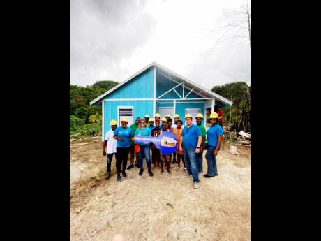 Marsha Burrell-Rose (left), development and marketing manager of Food For The Poor; Kathryn Silvera (second left), director of sales and marketing, Chas E. Ramson Limited, Dean Morris (centre) and her children; Phillip Ramson (second right), managing direc