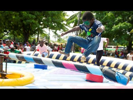 Malique Hendricks leaps over an obstacle while having a whale of a time at a back-to-school treat and fun day organised by dancehall deejay Popcaan, through his Popcaan Care Foundation, held at the Rudolph Elder Park in Morant Bay, St Thomas, on Thursday. 