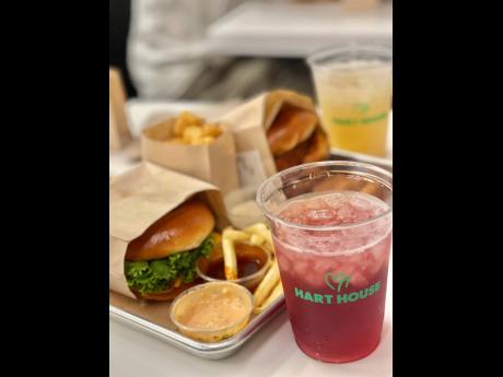 A double burg’r, crispy tots, crispy chick’n nuggets, french fries, Hart House signature dippin sauces, as well as berry patch and limeade drinks are pictured at Kevin Hart’s Hart House in Los Angeles. 