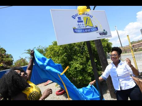 Nicola Jones (left), principal of Port Royal Primary School, and Nickeisha Walsh, executive director of Students’ Loan Bureau (SLB), unveiling a sign on Friday to mark a partnership between the Kingston-based educational institution and the state entity.