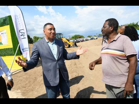 Prime Minister Andrew Holness (left) in conversation with Cliffford Drummond, vice-president of the Citizens’ Association of Daytona, at the ground-breaking ceremony for the Sandown Palms development in Portmore, St Catherine, on Friday.