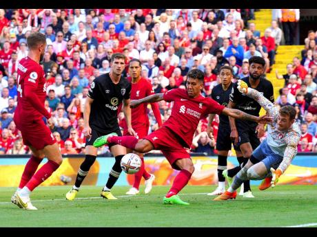 
Liverpool’s Roberto Firmino (centre) scores their side’s seventh goal of the game during the English Premier League match between Liverpool and Bournemouth at Anfield stadium in Liverpool, England, yesterday. Liverpool scored a record-tying 9-0 EPL wi