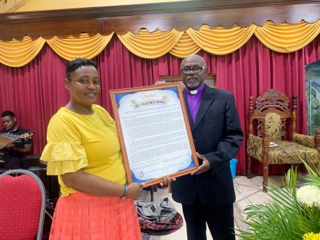 Diana Bowen presents a citation to Reverend Ralstan ‘RT’ Powell, who ended his 10-year stint at Glendevon New Testament Church of God on Sunday. He has been transferred to the Ocho Rios New Testament Church of God.