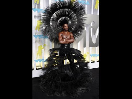 Lil Nas X wears Harris Reed’s February 2022 Collection 60 Years A Queen made from up-cycled feathers and black sequins with a matching headpiece by Vivienne H Lake.