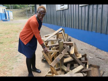 Vyonnie Whynes, principal McIntosh Memorial Primary, shows termite-infested furniture removed from classrooms that may have to be repaired to be reused next week.