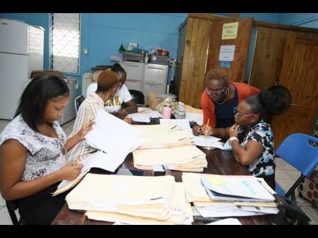 Vyonnie Whynes (second right), principal of McIntosh Memorial Primary School in Manchester, in discussion with staff as they prepare for the reopening of school next week.