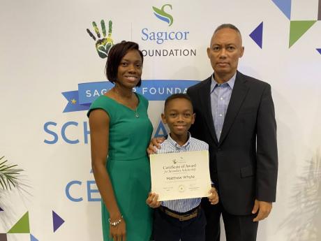 Matthew Whyte shares a moment with his parents, Debbie-Ann (left) and Herbert Whyte, after collecting his certificate at the Sagicor Foundation Scholarship and Awards Ceremony on Monday.
