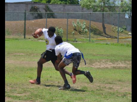 File photo shows Carl Thompson (left) as he tries to get away from Alex Rhule during a game of football (American) at the Breezy Castle playing field in Kingston on Thursday August 15, 2019. They boys were participating in a yearly summer camp, which is he