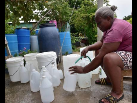 Diane Wilson, resident of Hill 60 in Cheswick, fills bottles with water from a standpipe near to her house. She has three bathrooms in her home – located 15 metres from the standpipe – but still has to bathe with buckets or bottles. 