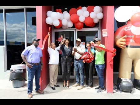 Karoline Smith, general manager of Sol Jamaica SRL(C) and Pearnel Charles Jr, MP Clarendon SE celebrate after cutting the  ribbon for the official opening of the Texaco Mineral Heights service station. 