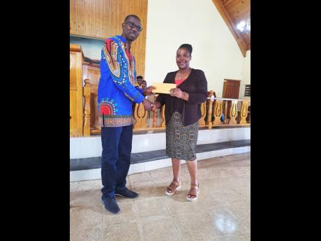 Founder and Chief Executive Officer of the Rejorn Campbell Love Foundation, Federica Campbell, hands over a donation of $40,000  to Pastor Noel Boyne of the Charlemont Open Bible Church on August 28.