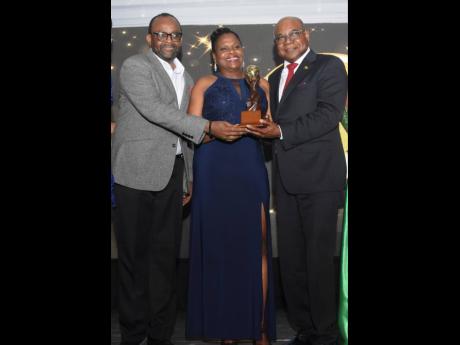 Minister of Tourism Edmund Bartlett (right) shares the three top awards that the country received with Permanent Secretary Jennifer Griffith and Director of Tourism Donovan White.