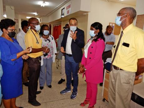 Jamaica’s Health Minister Dr Christopher Tufton (fourth left) and Manitoba’s Health Minister Audrey Gordon (fifth left) engage staff at the St Ann’s Bay Regional Hospital in discussion during a tour of the facility on Thursday. Others pictured are (f