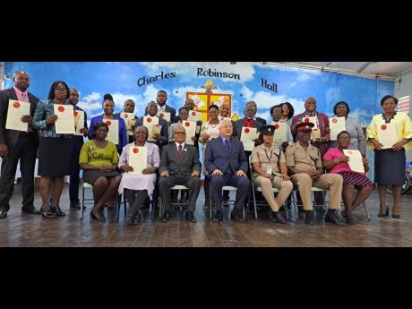 Justice Minister Delroy Chuck (seated at centre) and Custos of Portland Lincoln Thaxter (seated, third left) pose for a photo with the 20 new justices of the peace who were commissioned into office last Thursday.