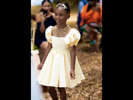 The flower girl, daughter of the beautiful couple, Madison Gayle makes her way up the aisle in her dress specially designed by her mother.