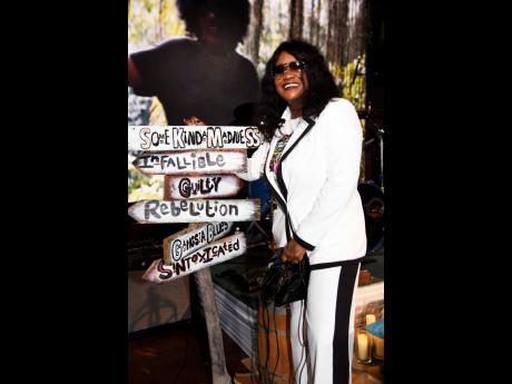 Tanya Stephens leans on a sign listing the names of all her albums, created by herself and her daughter.. 