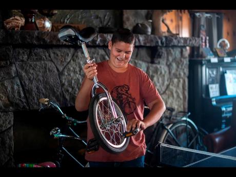 Daniel Giffin holds his unicycle at the Buffalo Lodge Bicycle Resort in Colorado Springs, Colo, on Wednesday, Aug 10, 2022. Giffin, 15, was diagnosed with brain cancer at age 11 and has since discovered a passion for e-biking. Prior to his diagnosis, Giffi
